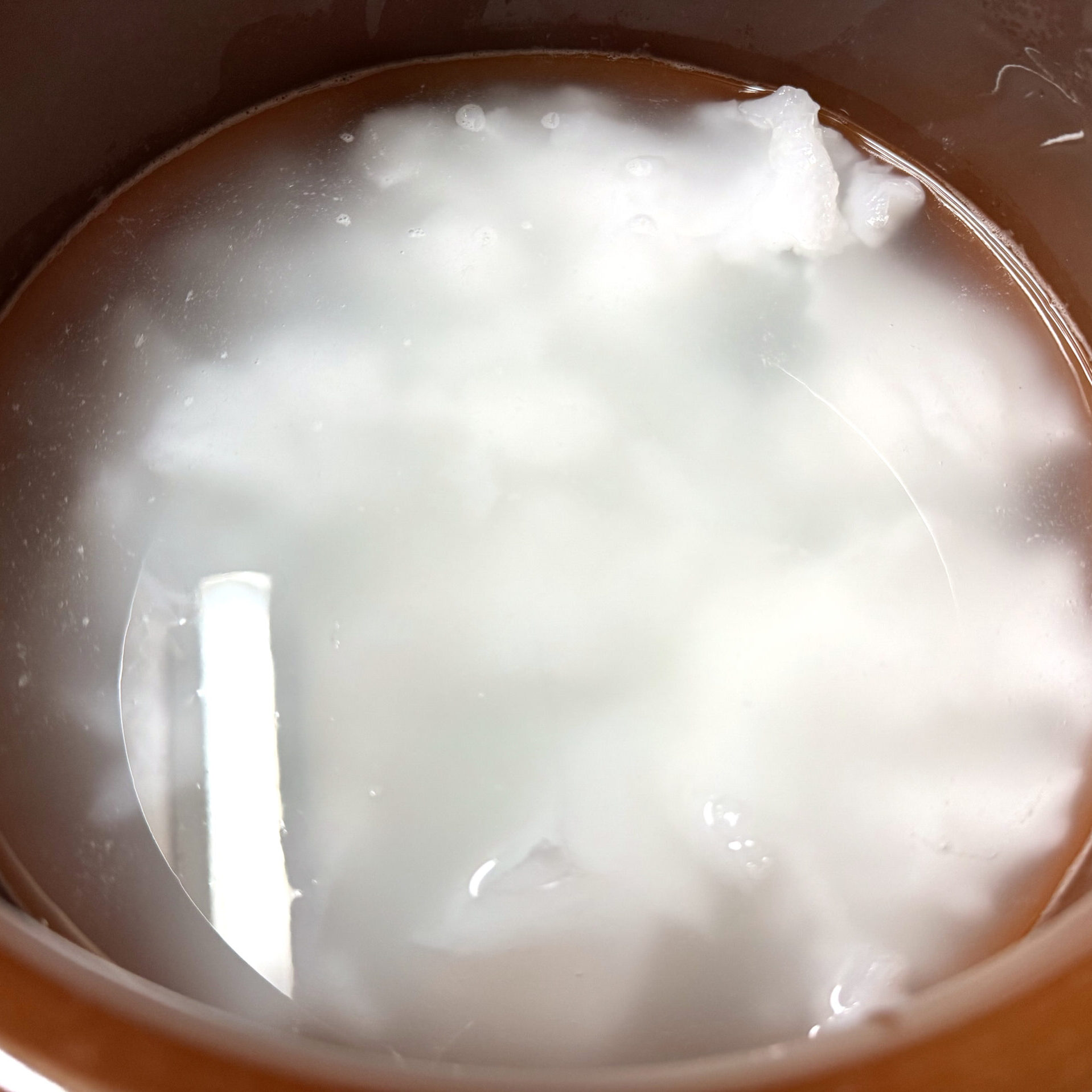 炊いた糊を甕に入れて水を張り保存する様子